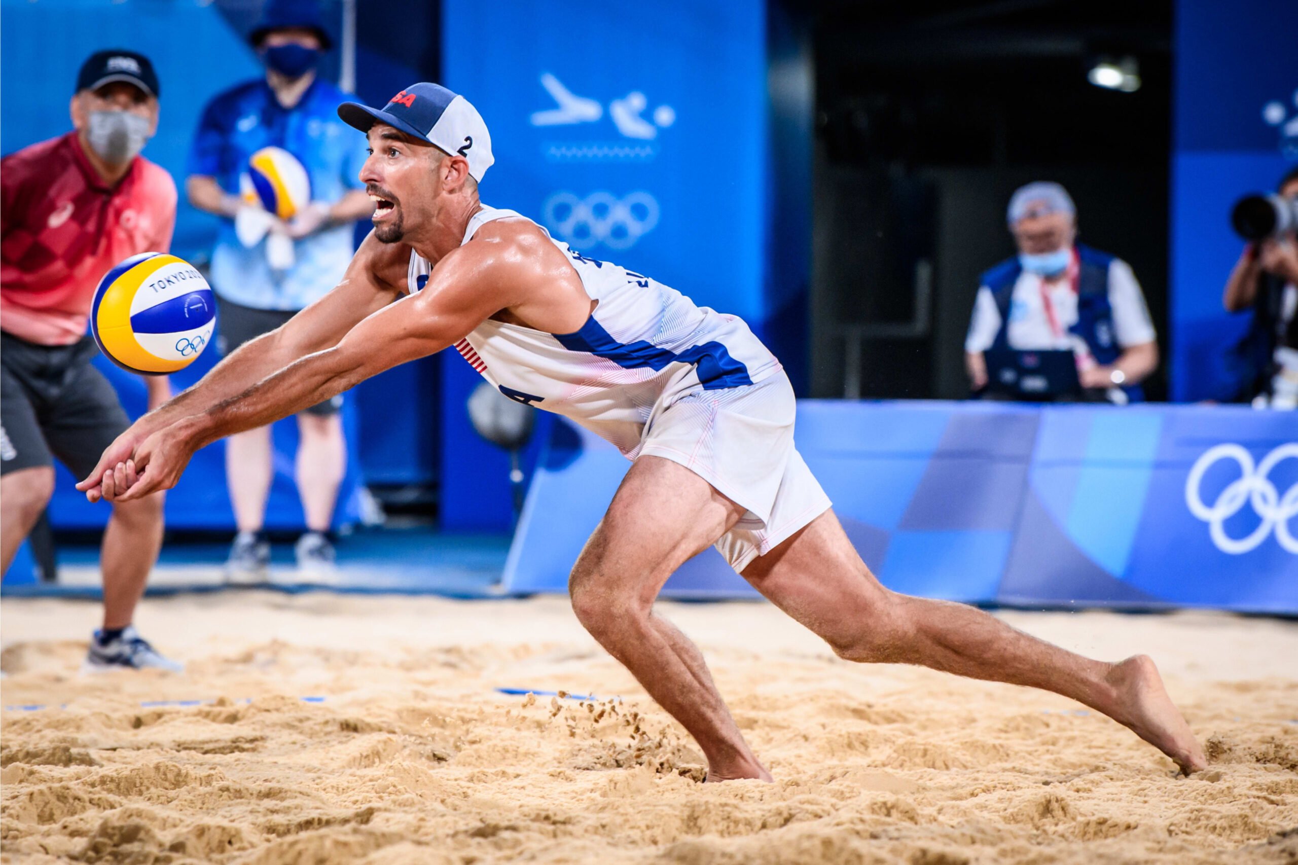 Nick Lucena dives to pass a ball during a beach volleyball match at the Tokyo 2020 Olympic Games
