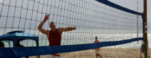 Man going up for an attack on the beach in Paravolley