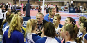 male coach talking to team of girls