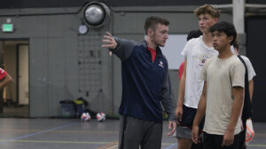 Male coach giving instruction to boys players