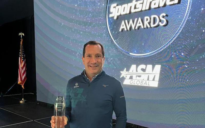 USAV CEO Jamie Davis holding the SportsTravel Award