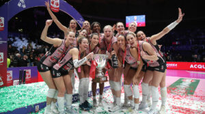 Women's volleyball team celebrates with a trophy