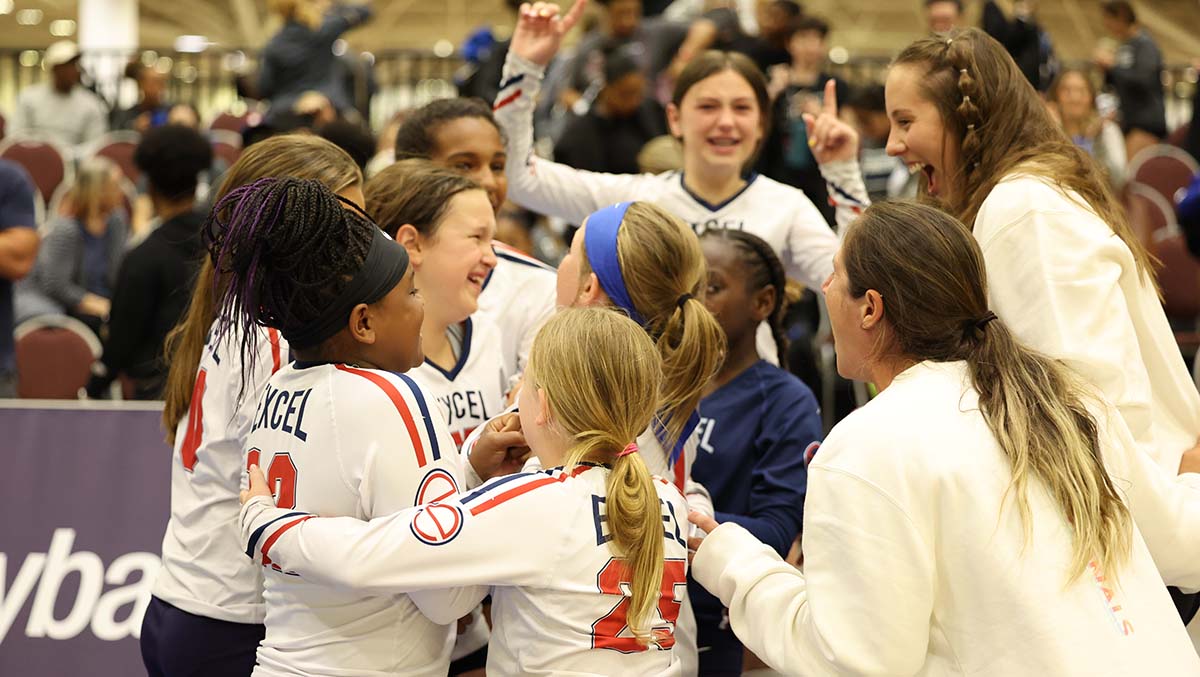 A group of girls celebrate a win on the volleyball court