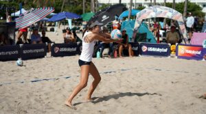 A young woman playing beach volleyball