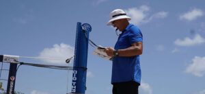 Male referee at the beach standing on his platform looking at a scoresheet