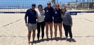 Five people standing on the beach