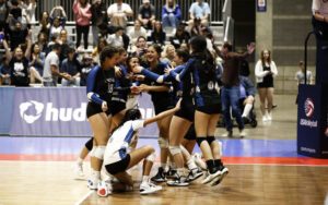 A group of girls huddle in the court.