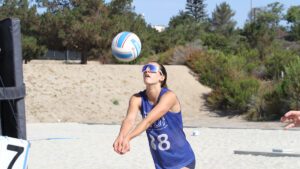 a girl passes the ball on the beach