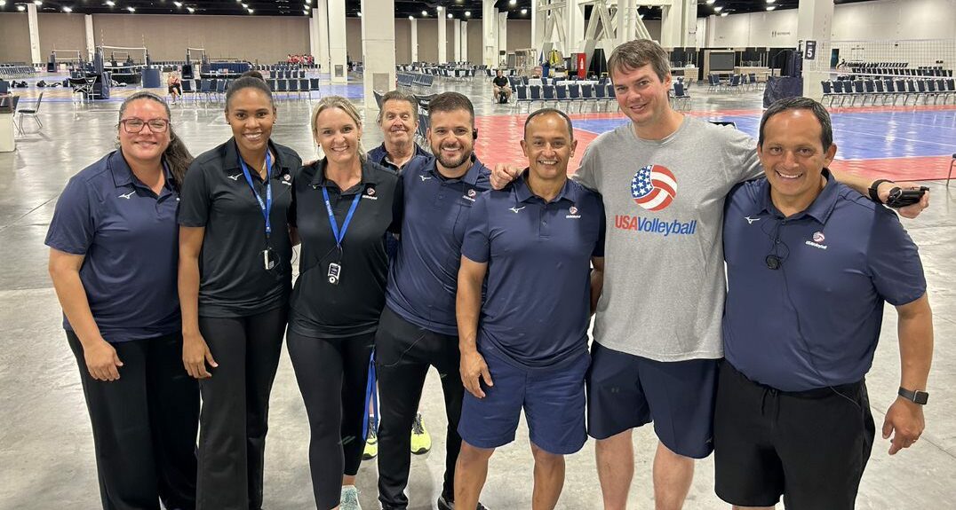 A group of coaches standing and smiling at the camera