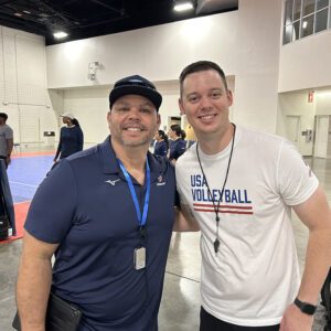 Two male coaches smiling looking at the camera