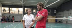 A female coach and male coach talking to each other