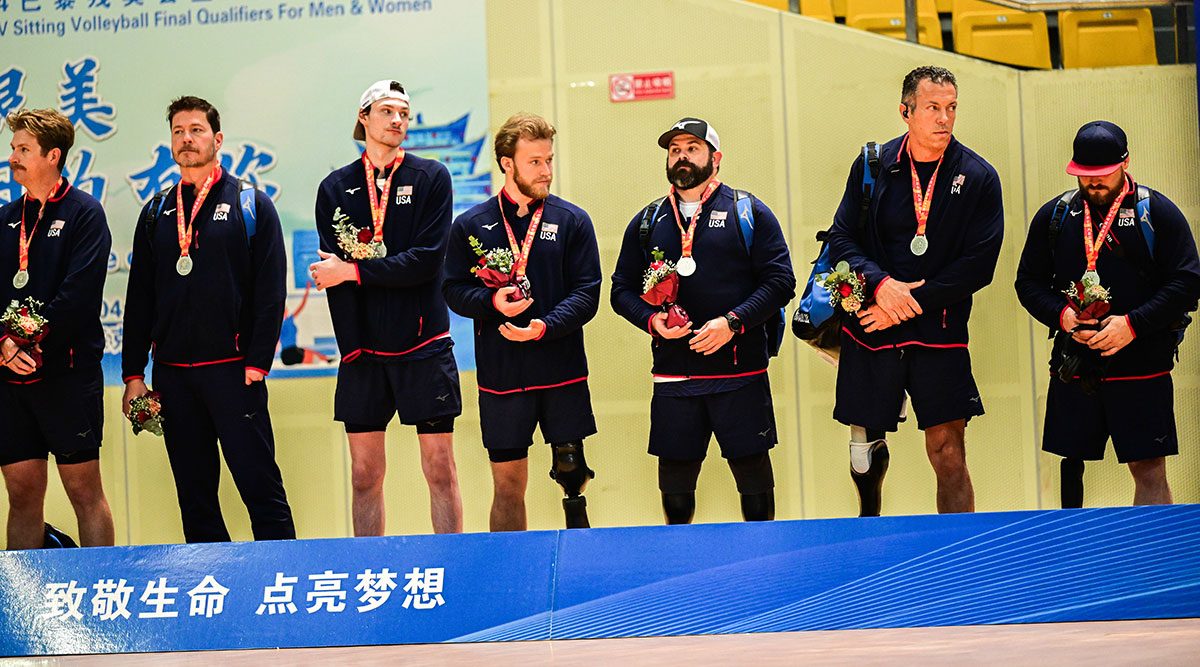 Members of the U.S. Men's Sitting Team with medals and flowers