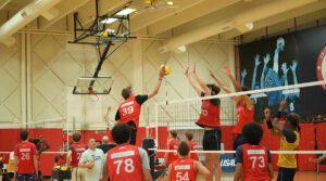 A boys volleyball player attacks the ball with the block up