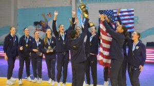 The 2024 girls u19 team celebrates with their medals and the USA flag