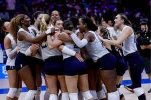 Photo of U.S. Women's National Team huddled on the court, celebrating win over France at Volleyball Nations League