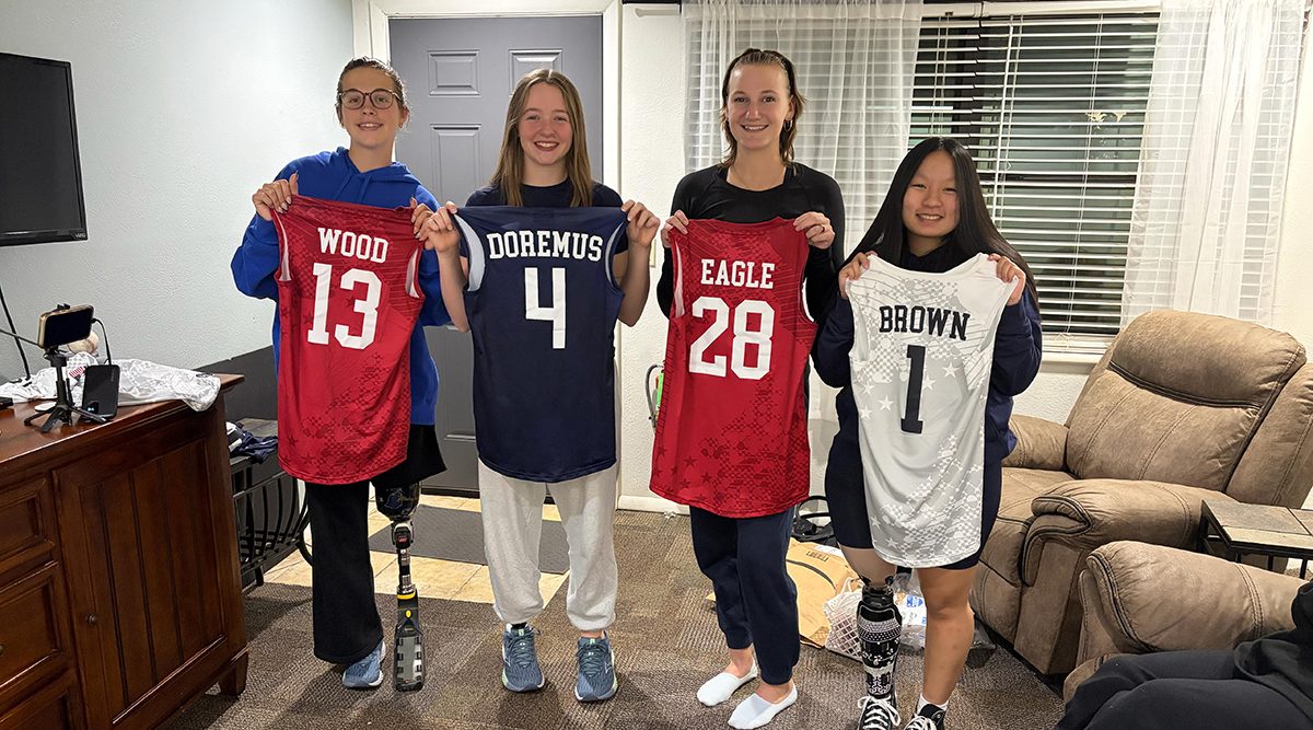 The four athletes participating in the Youth Parapan Games hold up their jerseys