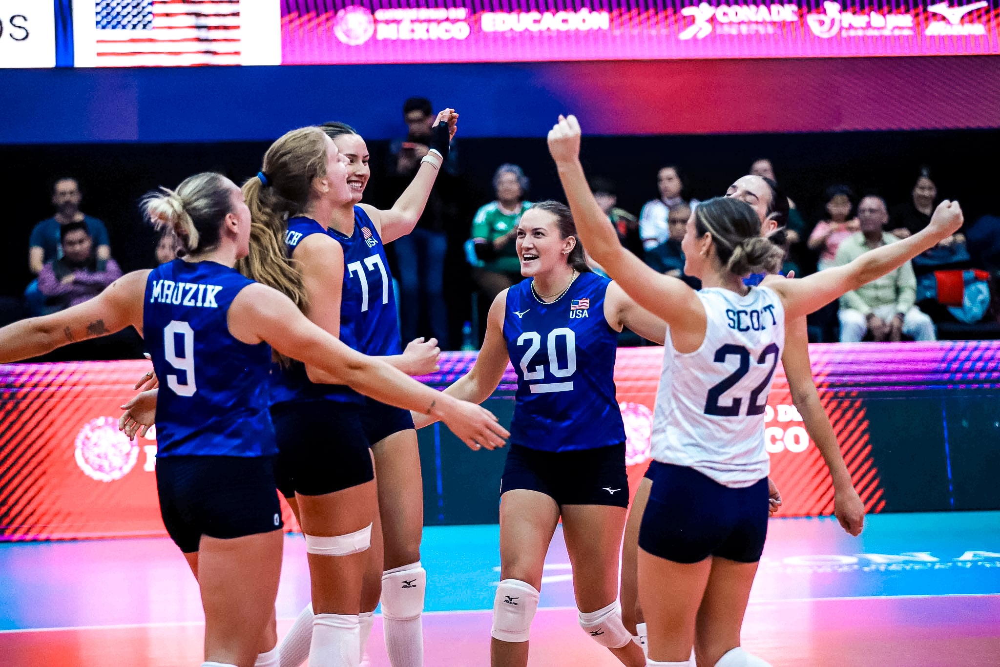 Rachel Fairbanks and the Women's National Team celebrate in a huddle.