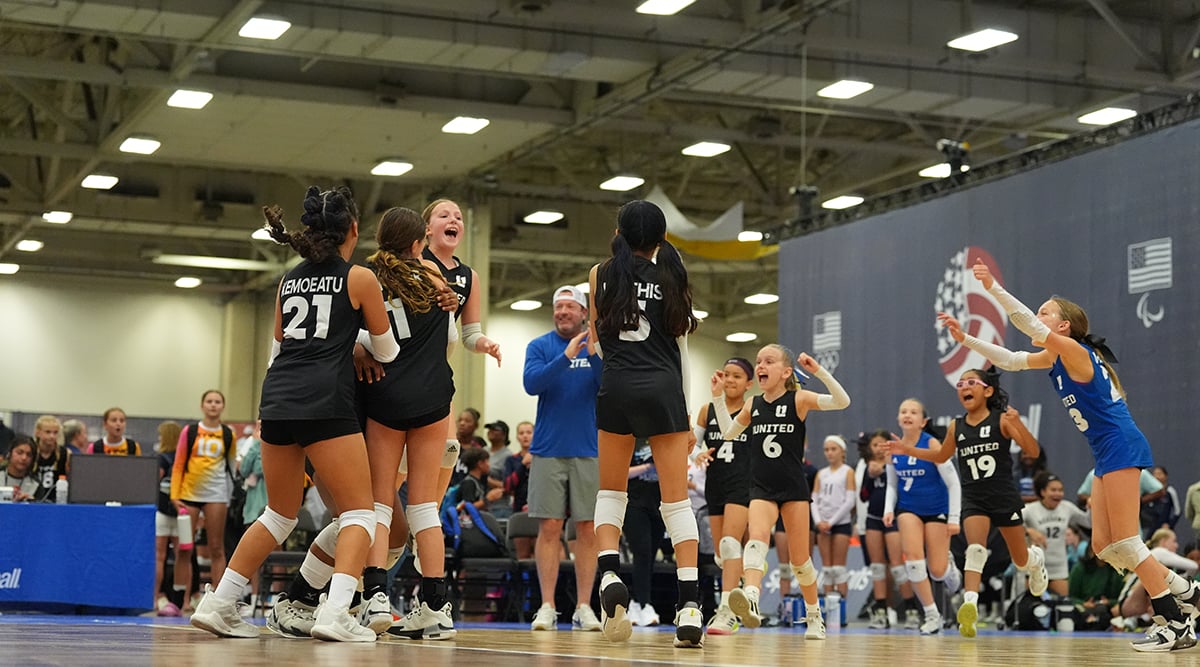A group of athletes on the court celebrating